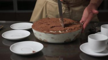 Yakından bakınca geleneksel İtalyan Tiramisu tatlısının ustalıkla servis edildiğini görüyoruz. Cömertçe kakao tozuyla kaplanmış bu zengin, kremalı, kahve aromalı şeker aile toplantılarında, özel günlerde veya