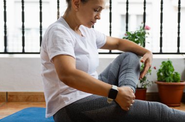 Enerjili kadın, serin bir iç mekan ortamında serinliyor, yeşillik ortasındaki refahı ve esnekliği arttırıyor..