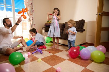 Canlı bir aile içeride birlikte kaliteli zaman geçirir renkli balonlarla meşgul olur ve neşeli anılar yaratır. Sahne sevgiyi, yaratıcılığı ve aile bağlarını yansıtıyor..