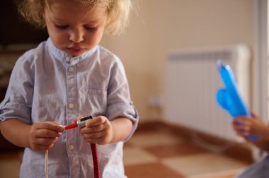 Küçük bir çocuk nesneleri merakla araştırır, bir keşif anını yakalar ve kapalı bir ortamda öğrenir..