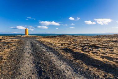 Soğuk bir yürüyüş gününde İzlanda sahilindeki deniz feneri.