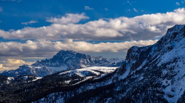 Sun goes down on an alpine valley in italy during a snowy winter clipart