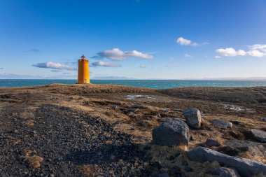 Soğuk bir yürüyüş gününde İzlanda sahilindeki deniz feneri.