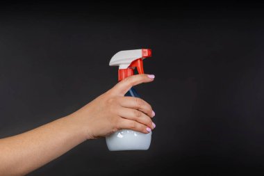 Bir şişe beyaz sıvıyla mavi sprey. Bitki spreyi tedavisi. Yüzey tedavisi, temizlik. koyu arkaplanda izole