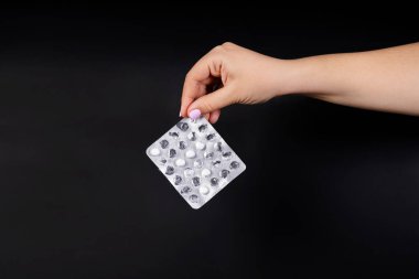 Siyah arka planda beyaz tabletlerle su toplamış. Kabarcıklardaki bazı tabletler kullanılmış.