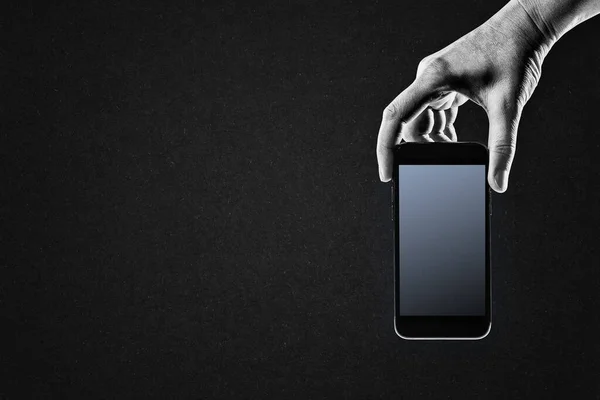 テクスチャードペーパーの背景 コピースペースに黒と白の携帯電話を保持する手 ロイヤリティフリーのストック画像