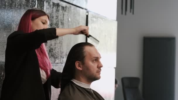 Fryzjer Czesający Długie Włosy Mężczyzny Nowoczesnym Salonie — Wideo stockowe
