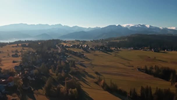Önünde Tarlalar Arkasında Güneş Doğarken Sıradağlar Olan Bir Köyün Havadan — Stok video