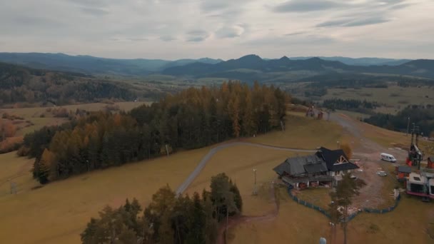 一个滑雪站的空中景观 该站有一条弯曲的道路 山上有秋天的森林 — 图库视频影像