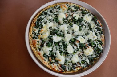 Ispanak, domates ve mozzarella içeren lezzetli vejetaryen pizza.