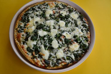 Ispanak, domates ve mozzarella içeren lezzetli vejetaryen pizza.