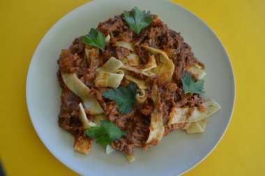 Maydanoz yapraklarıyla süslenmiş biftek ragu pappardelle.