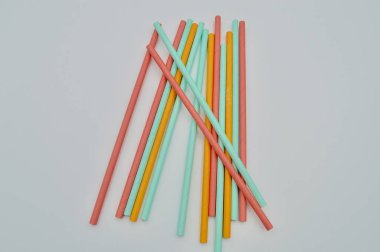 Renkli kağıt beyaz arka planda pipet içiyor