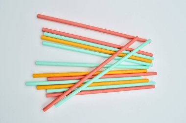 Renkli kağıt beyaz arka planda pipet içiyor