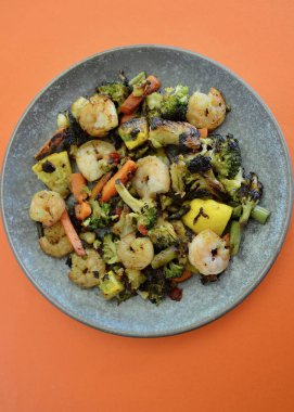 Shrimp with pan fried vegetables on a plate
