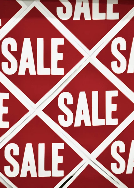 A closeup of red and white SALE stickers in a shopping mall