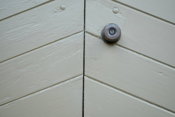 Крупный план тяжелой деревянной двери, окрашенной в серый цвет