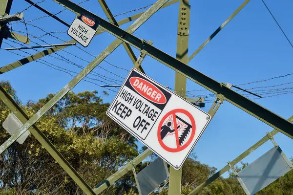sign of an old pole with warning lines and cables