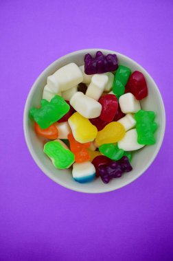 Renkli bir arka plana karşı bir kase şeker