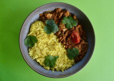 Safranlı tavuk kişniş yapraklarıyla süslenmiş pirinç..