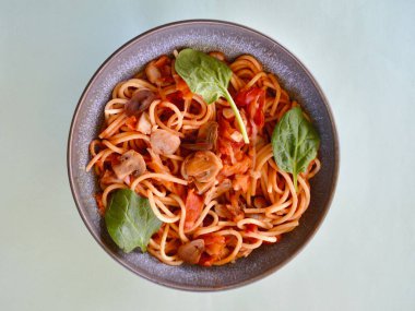 Spagetti Primavera bebek ıspanak yapraklarıyla süslenmiş bir kasede..