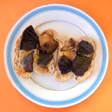 Tavada kızartılmış Portobello mantarı ve karışık tahıllı ekşi ekmek..