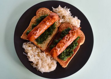 Knackwurst spinach and sauerkraut on toasted continental style bread.  clipart