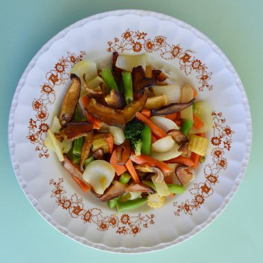 Uzun tahıllı pirinç yatağında Shiitake mantarı bulunan kızarmış Asya sebzelerini karıştır.. 