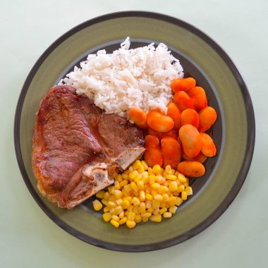 Mısır, pirinç ve dev Yunan fasulyeli bir T-Bone bifteği.. 