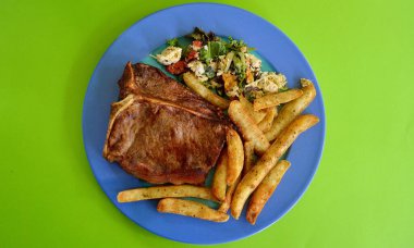 Tayland hindistan cevizi salatası ve tabakta patates kızartması ile biftek..