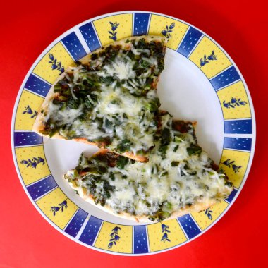 Tabakta ıspanaklı ve peynirli pizza.