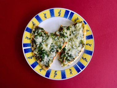 Tabakta ıspanaklı ve peynirli pizza.