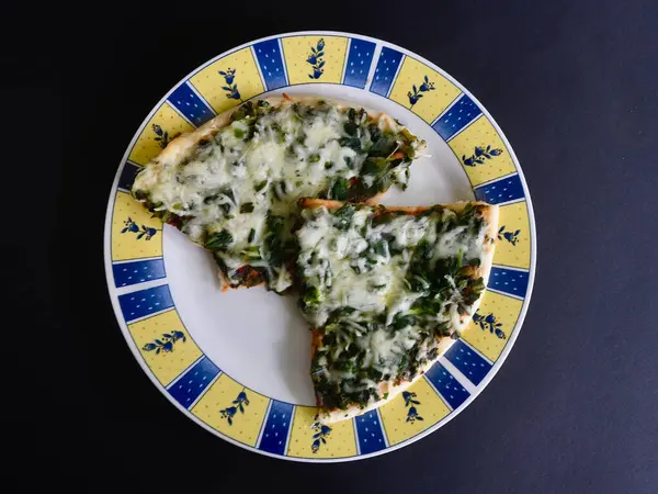 Tabakta ıspanaklı ve peynirli pizza.