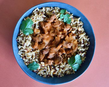 Kırmızı, kahverengi ve yabani pirinç tanelerinden oluşan bir yatakta sığır eti kebabı..