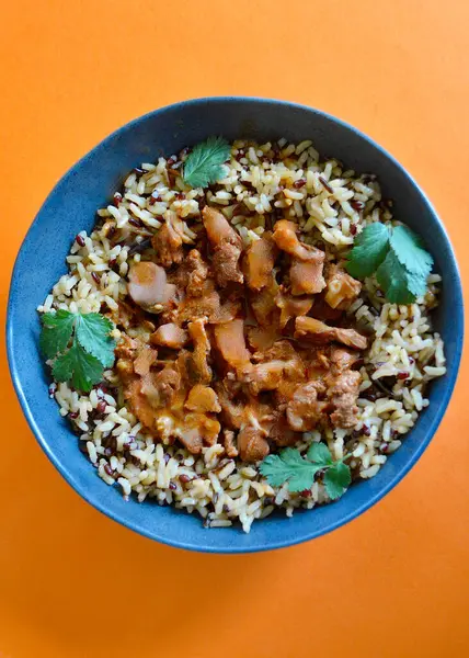 Kırmızı, kahverengi ve yabani pirinç tanelerinden oluşan bir yatakta sığır eti kebabı..