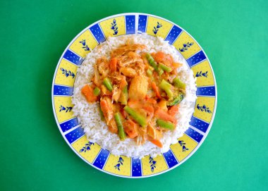 Pirinçli bir tabakta tereyağlı tavuk ve sebze manzarası.. 