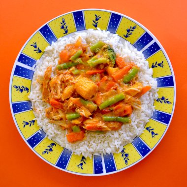 Pirinçli bir tabakta tereyağlı tavuk ve sebze manzarası.. 