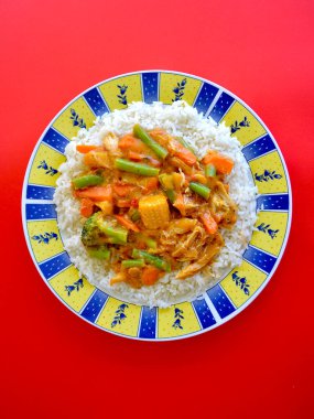 Pirinçli bir tabakta tereyağlı tavuk ve sebze manzarası.. 