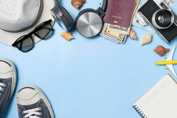 stock image Traveler accessories, vintage camera, dollar banknote in passport and black sneaker on blue  background for summer holiday and vacation concept.