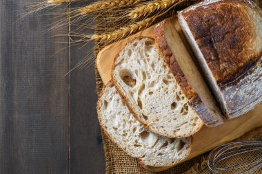 Ahşap zemin üzerinde dilimlenmiş ekşi ekmeğin üst görünümü, ev yapımı fırın konsepti