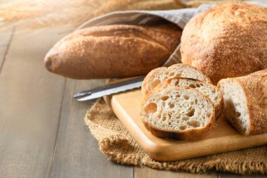 Home made sliced baguette bread on wood background, bread and bakery concept