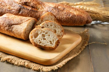 Home made sliced baguette bread on wood background, bread and bakery concept