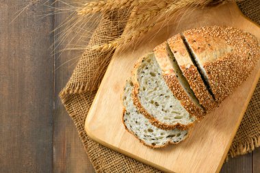 Top view of sliced french grain breads with white and black sesame on wood background, home made bakery concept