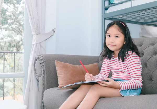 cute girl paint or do homework on sofa in living room, learn and relax concept