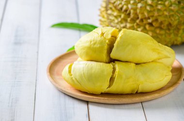 Durian meyvesi. Tahta tabakta olgun bir Monthong Durian ve beyaz ahşap zemin, Tayland 'ın yaz mevsiminde meyve kralı.