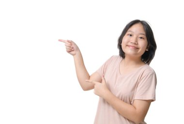 Genç bir çocuk bir ürün ya da fikir sunmak için parmağıyla bir tarafı işaret ediyor. Boşluğu işaret eden genç bir kız. Mutlu kız yüzü, pozitif ve gülümseyen duygular.