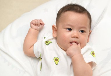 Thumbs or fingers sucking in baby newborn habit for calm and relax. Asian infant baby open mouth and putting fingers in to sucking feel secure.Baby newborn habit concept