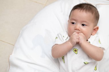 Baş parmaklar ya da parmaklar yeni doğan bebek alışkanlığını içine çekiyor ve rahatlıyor. Asyalı bebek ağzını açar ve parmaklarını emmeye sokar. Bebek alışkanlığı konsepti.