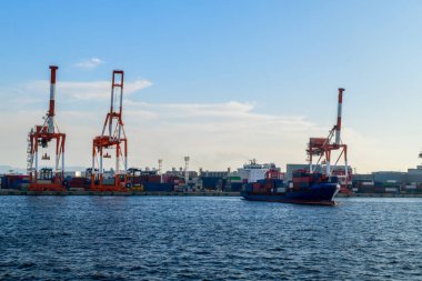 Japon adası Honshu, Osaka, Japonya 'daki Osaka limanında büyük vinçler, deniz kargoları, büyük liman kenti ve ticaret merkezi..