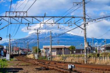 Güneşli bir günde Japonya 'da Fuji Dağı ile Demiryolu Rayları ve Elektrik Hatları